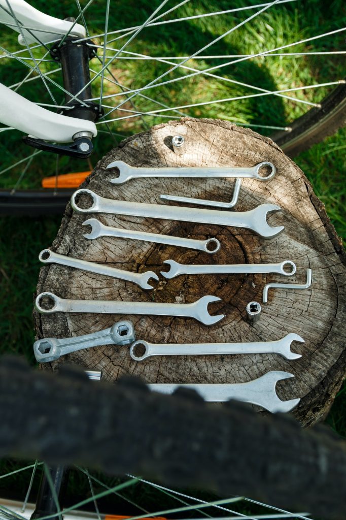 Tools, instrument for repairing bike on the wooden background outdoor wheel. Bicycle repair.